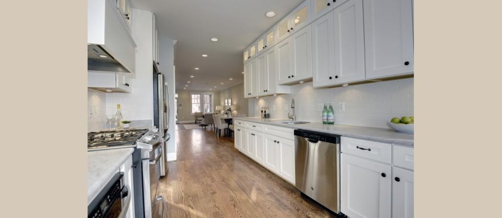 Example of a mid-sized transitional galley medium tone wood floor eat-in kitchen design in DC Metro with an undermount sink, shaker cabinets, white cabinets, marble countertops, white backsplash, subway tile backsplash and stainless steel appliances