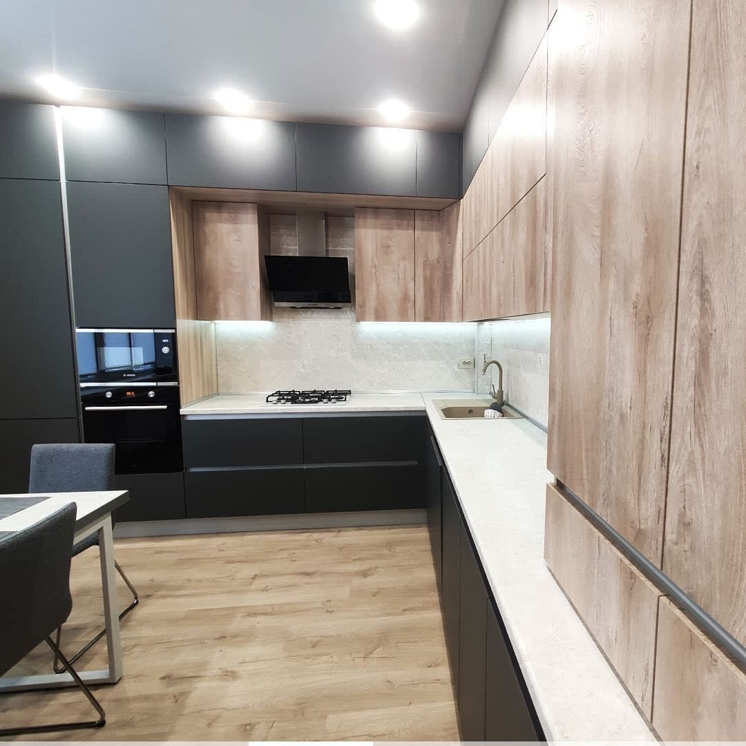 Большая широкая угловая кухня с матовыми и древесными фасадами