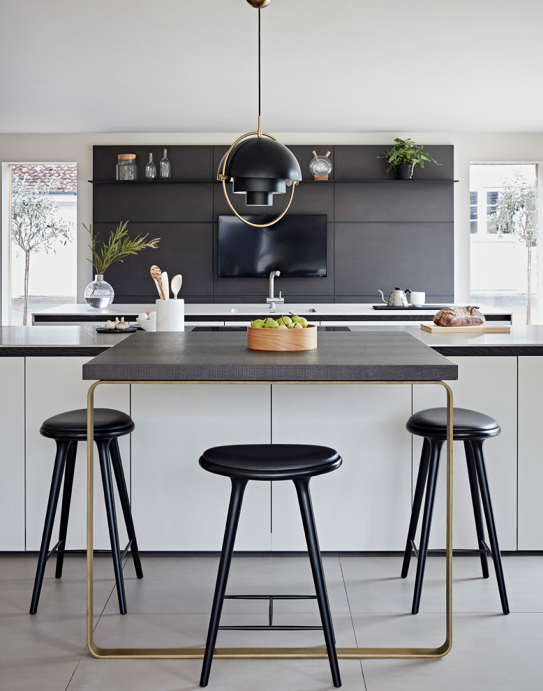 This is an example of a contemporary single-wall kitchen in Other with an integrated sink, flat-panel cabinets, grey cabinets, quartz benchtops, white splashback, engineered quartz splashback, black appliances, ceramic floors, multiple islands, white floor and white benchtop.