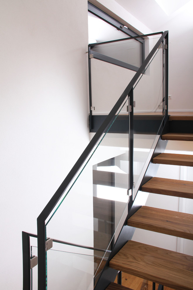 Design ideas for a mid-sized industrial wood straight staircase in Stuttgart with metal railing.