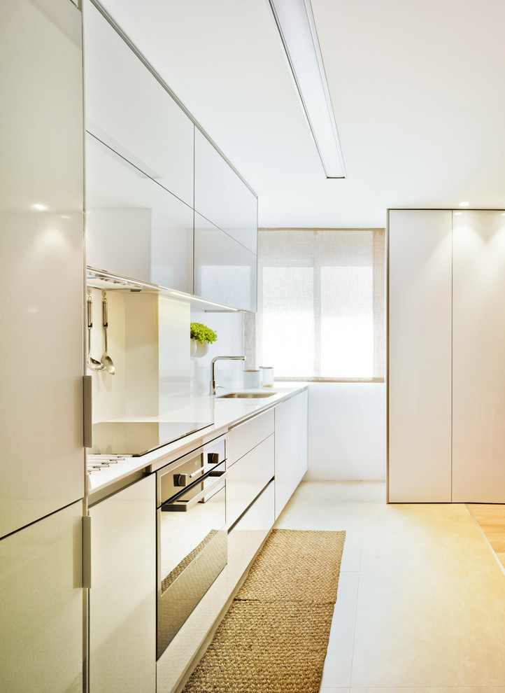 Photo of a mid-sized contemporary single-wall eat-in kitchen in Other with flat-panel cabinets, white cabinets, white splashback and no island.