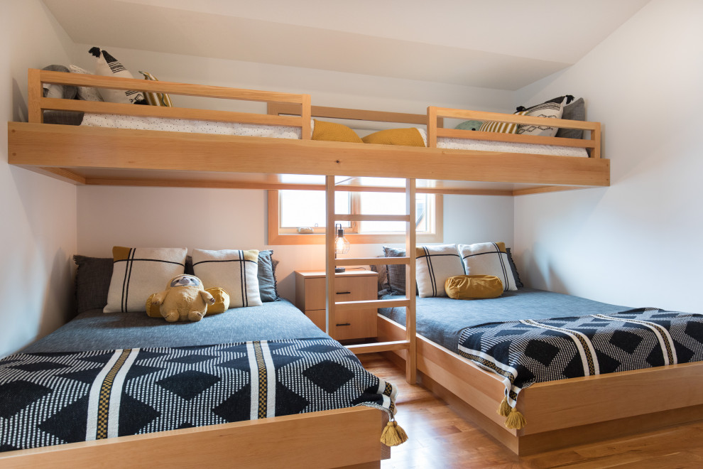 Aménagement d'une chambre d'enfant montagne de taille moyenne avec un mur blanc, un sol en bois brun et un sol marron.