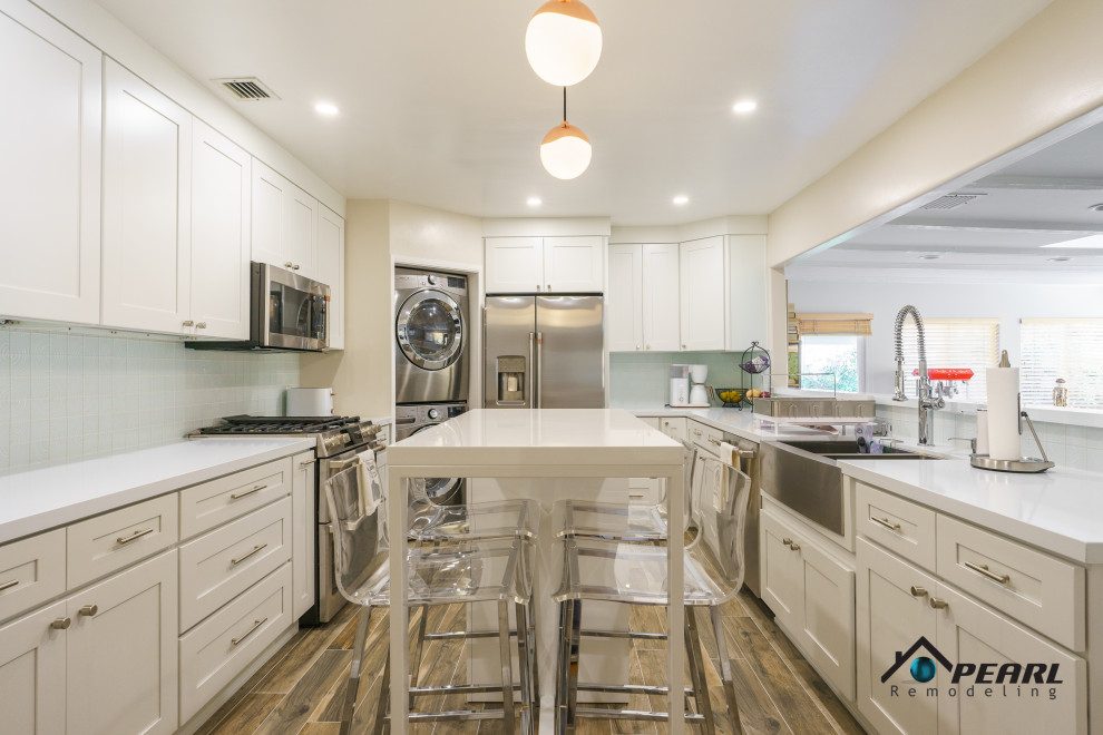 Idéer för att renovera ett stort funkis vit vitt kök, med en rustik diskho, skåp i shakerstil, vita skåp, bänkskiva i koppar, vitt stänkskydd, stänkskydd i stenkakel, rostfria vitvaror, ljust trägolv, en köksö och brunt golv