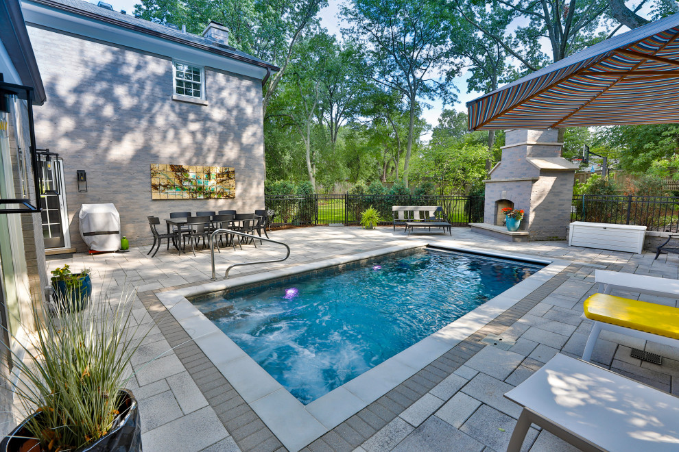 Design ideas for a small traditional backyard rectangular lap pool in Chicago with a pool house and concrete pavers.