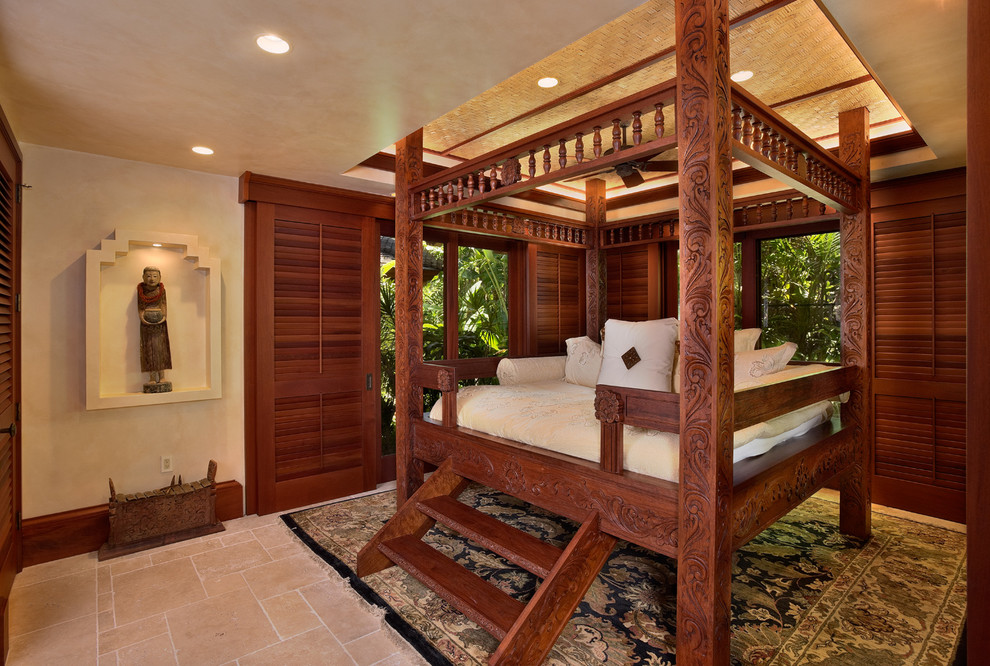Large tropical bedroom in Hawaii with beige walls, travertine floors, no fireplace and beige floor.