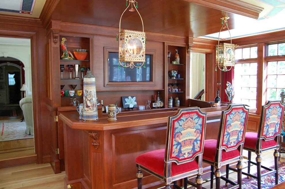 Design ideas for a traditional galley seated home bar in Philadelphia with light hardwood floors, medium wood cabinets, wood benchtops, brown floor and brown benchtop.
