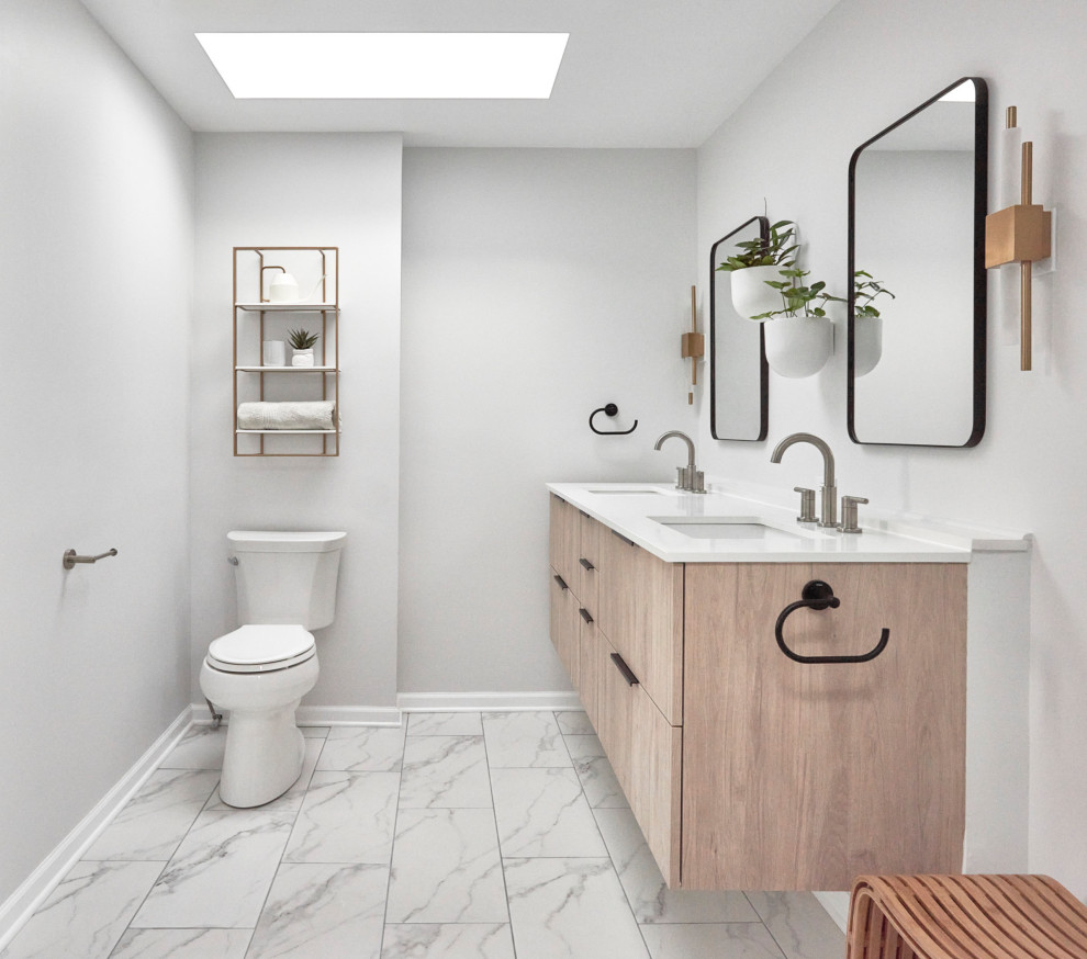 Inspiration for a mid-sized transitional master bathroom in Chicago with flat-panel cabinets, light wood cabinets, a freestanding tub, a curbless shower, a two-piece toilet, gray tile, porcelain tile, white walls, ceramic floors, a drop-in sink, quartzite benchtops, white floor, an open shower, white benchtops, a niche, a double vanity and a floating vanity.