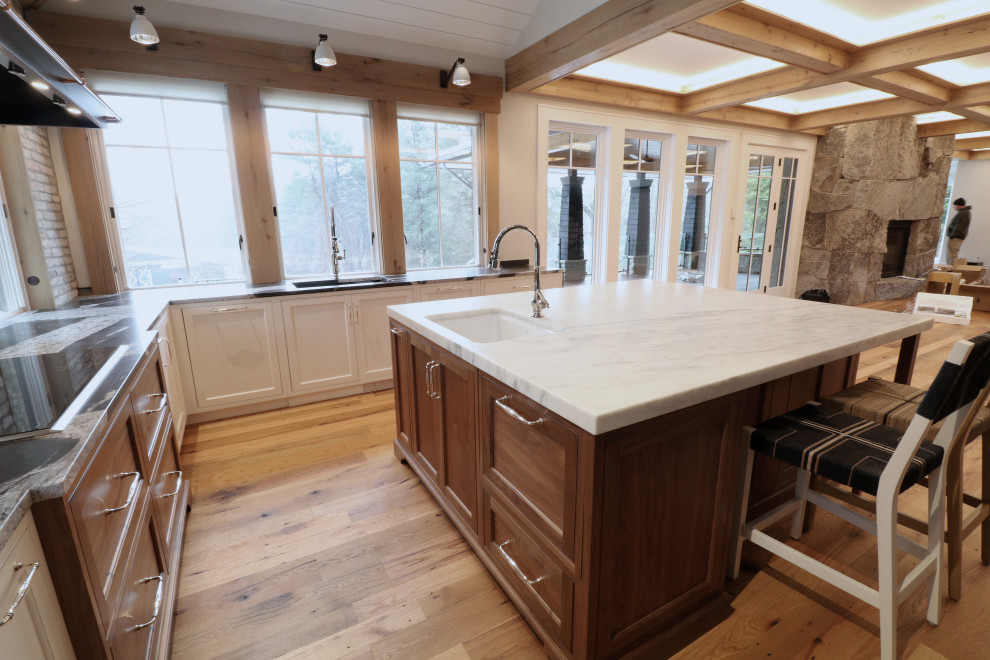 This is an example of an expansive transitional u-shaped eat-in kitchen in Boston with a farmhouse sink, beaded inset cabinets, marble benchtops, multi-coloured splashback, brick splashback, stainless steel appliances, medium hardwood floors, with island, multi-coloured floor and multi-coloured benchtop.