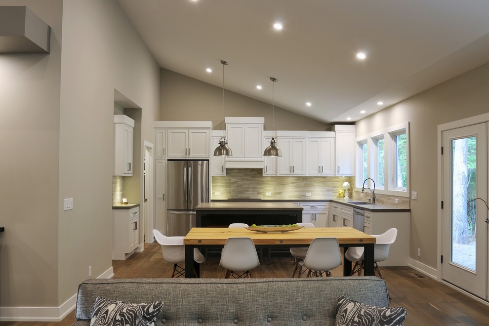 Open concept kitchen - large transitional l-shaped dark wood floor open concept kitchen idea in Grand Rapids with an undermount sink, shaker cabinets, white cabinets, quartz countertops, beige backsplash, porcelain backsplash, stainless steel appliances and an island