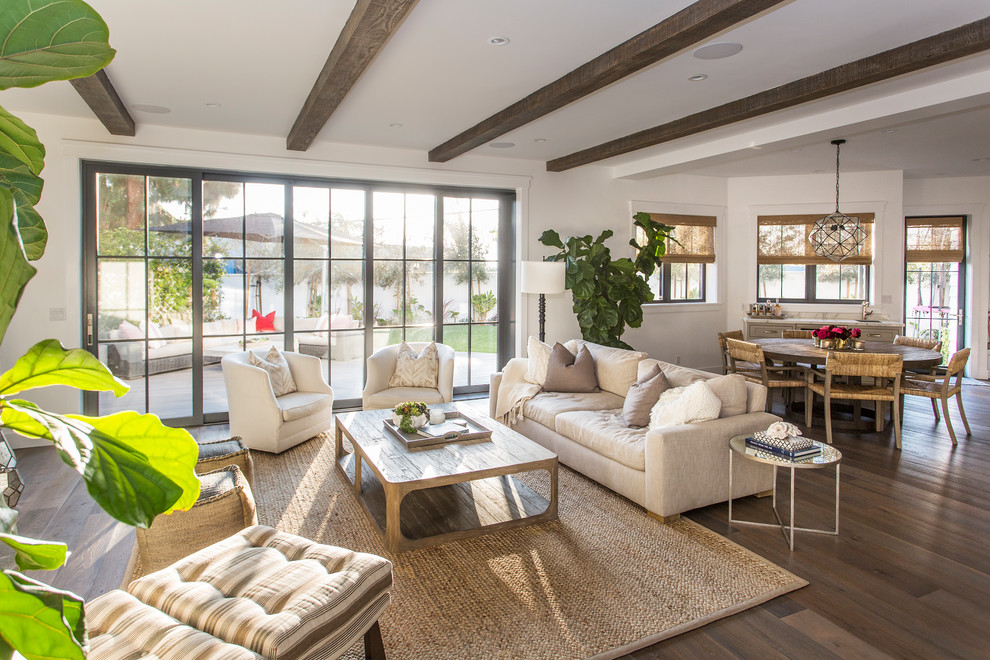 This is an example of a beach style open concept family room in Los Angeles with white walls, medium hardwood floors and brown floor.