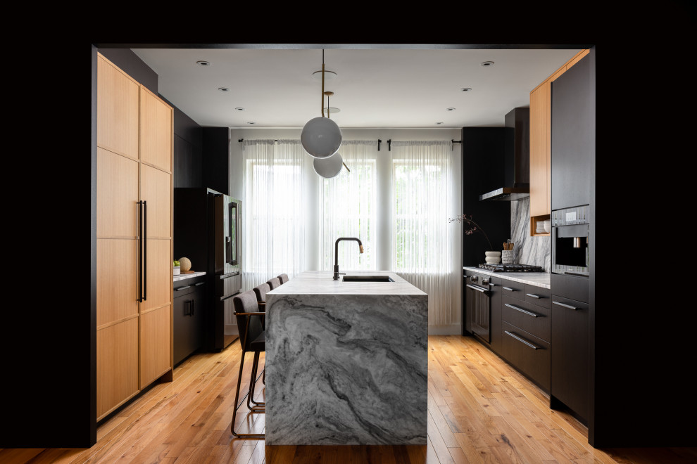 This is an example of a contemporary kitchen in Philadelphia with a submerged sink, flat-panel cabinets, black cabinets, black appliances, medium hardwood flooring, an island and brown floors.