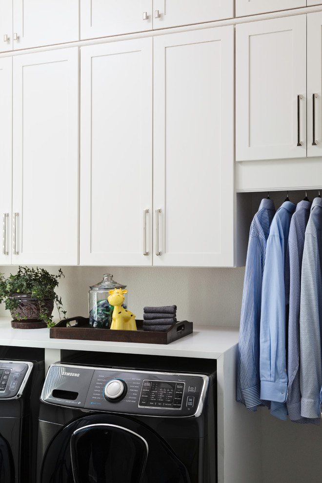 Dedicated laundry room - large transitional single-wall dedicated laundry room idea in Orlando with shaker cabinets, white cabinets, solid surface countertops, a side-by-side washer/dryer and white countertops
