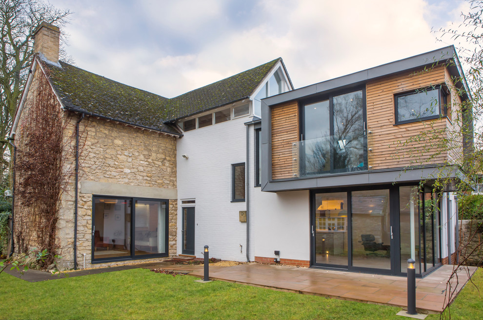 Contemporary two-storey white exterior in Oxfordshire with wood siding.