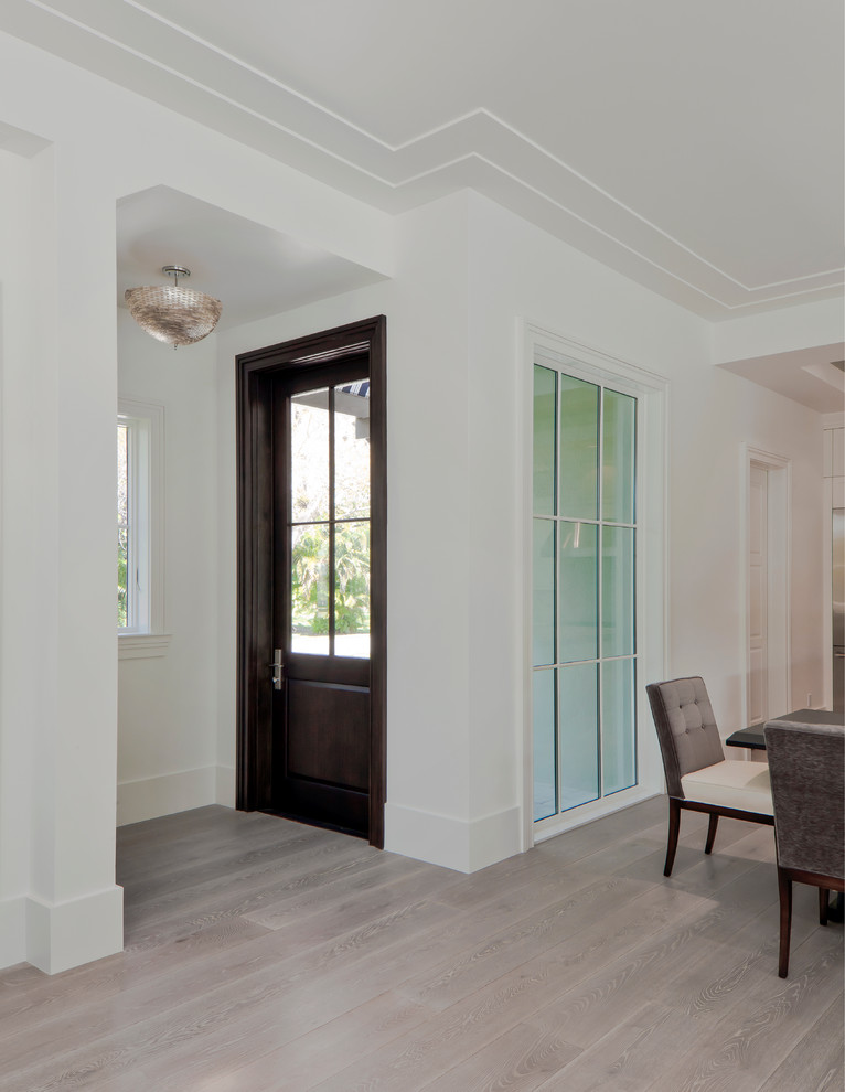 Inspiration for a small transitional light wood floor front door remodel in Miami with white walls and a dark wood front door