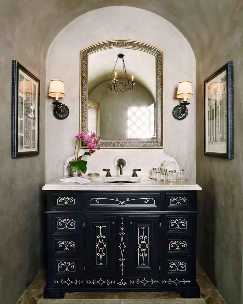 This is an example of a mediterranean powder room in San Francisco with raised-panel cabinets, black cabinets and grey walls.