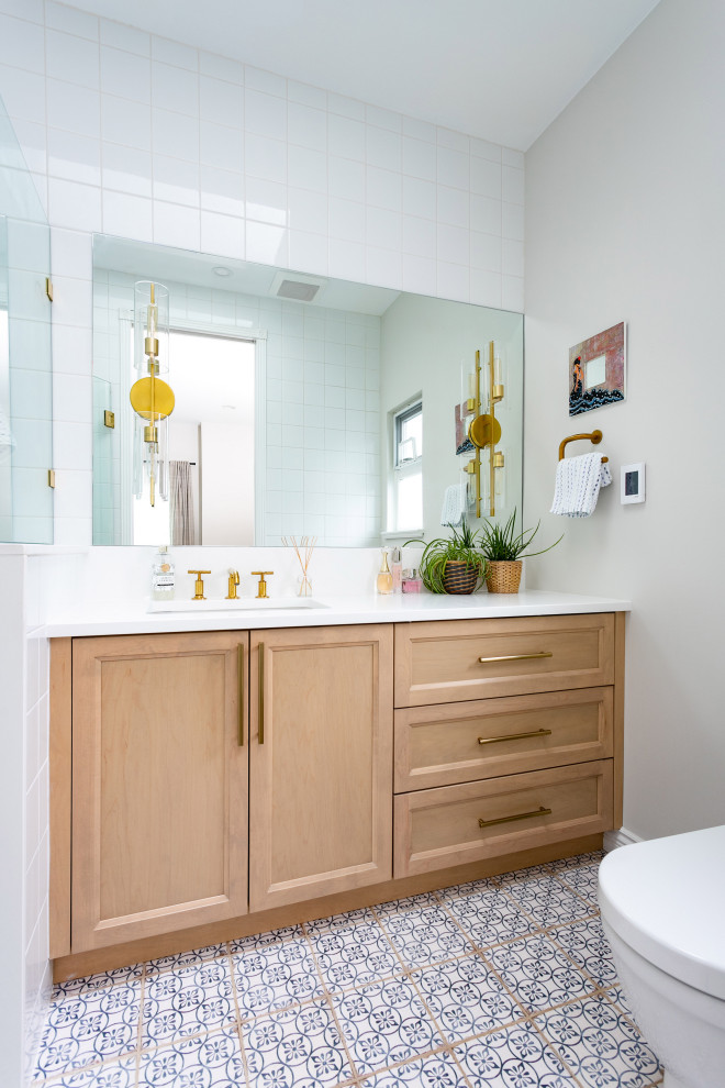 Inspiration for a mid-sized transitional 3/4 white tile and ceramic tile porcelain tile, multicolored floor and single-sink bathroom remodel in Vancouver with shaker cabinets, medium tone wood cabinets, white walls, an undermount sink, quartz countertops, white countertops and a built-in vanity