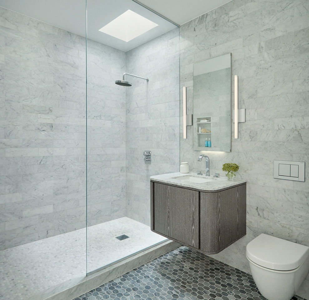 Photo of a large contemporary master bathroom in New York with flat-panel cabinets, medium wood cabinets, an open shower, a wall-mount toilet, gray tile, marble, grey walls, mosaic tile floors, an undermount sink, marble benchtops, grey floor and an open shower.