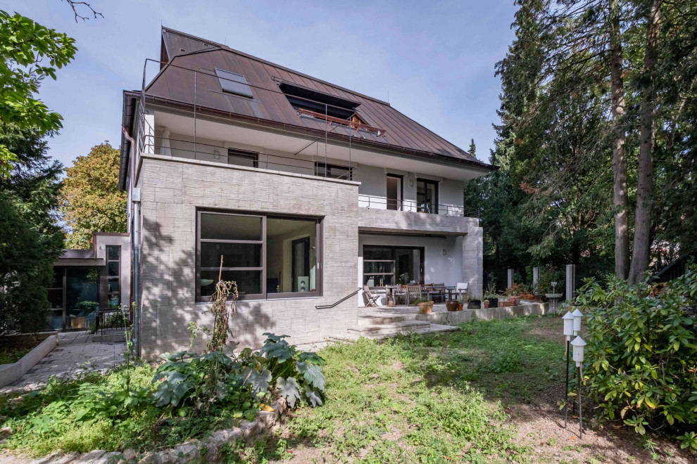 This is an example of a large contemporary concrete house exterior in Munich with three floors.