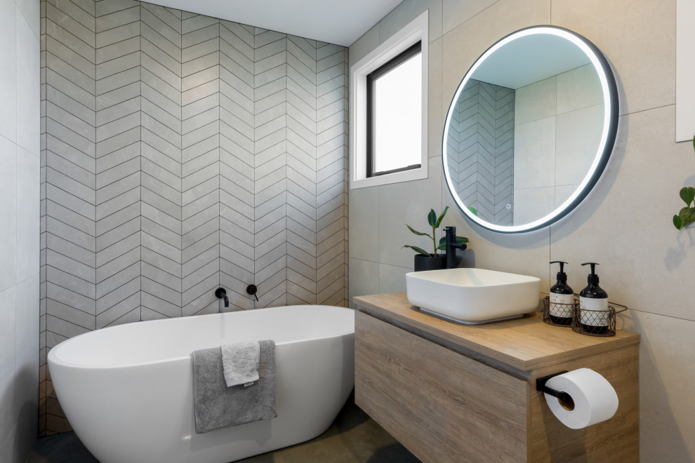 Inspiration for a large modern kids bathroom in Other with light wood cabinets, a freestanding tub, gray tile, grey walls, laminate benchtops, grey floor, a single vanity and a floating vanity.