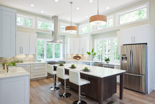 A two-tone kitchen featuring white lower kitchen cabinet units, black-framed upper cabinets with reeded glass, and a blue tile backsplash.