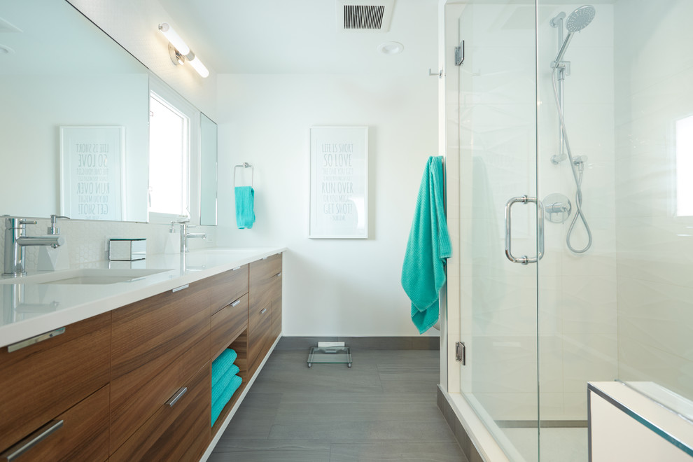Contemporary master bathroom in Edmonton with flat-panel cabinets, medium wood cabinets, an alcove shower, gray tile, ceramic tile, white walls, ceramic floors, an undermount sink, engineered quartz benchtops and a hinged shower door.