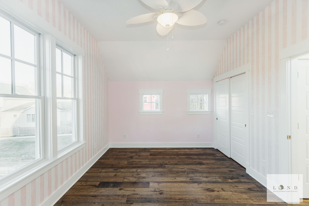 Inspiration för mellanstora amerikanska gästrum, med rosa väggar, mörkt trägolv och brunt golv