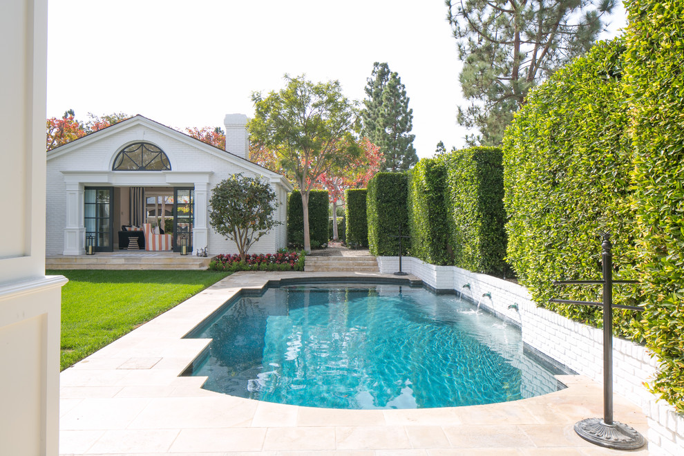 Design ideas for a traditional custom-shaped pool in Orange County with a pool house.
