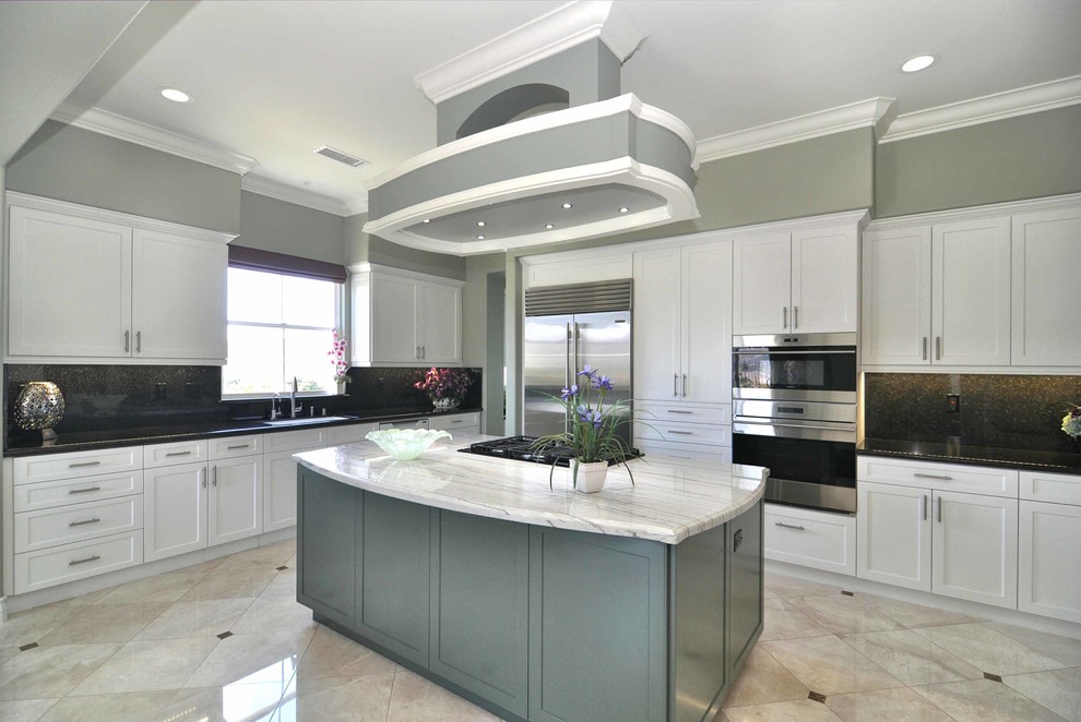 Photo of a large traditional eat-in kitchen in Los Angeles with shaker cabinets, white cabinets, marble floors and with island.