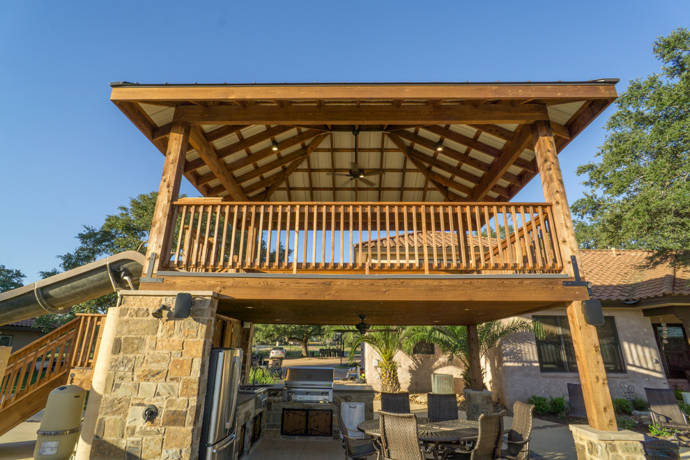 Inspiration for a large rustic backyard stone patio fountain remodel in Austin with a gazebo