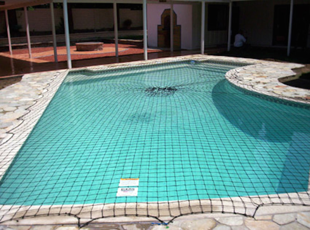 Mid-sized backyard stone and l-shaped hot tub photo in Miami