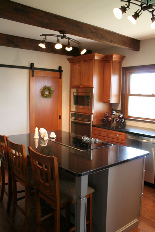 Kitchen - mid-sized transitional l-shaped medium tone wood floor kitchen idea with an undermount sink, recessed-panel cabinets, medium tone wood cabinets, granite countertops, white backsplash, ceramic backsplash, stainless steel appliances and an island