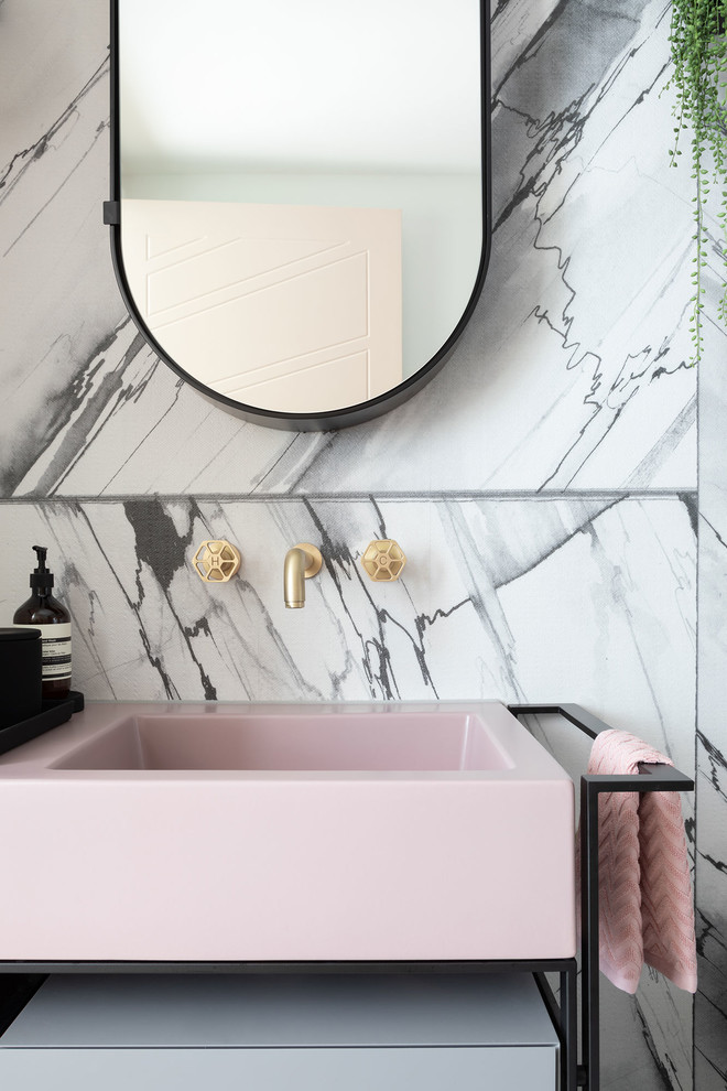 Photo of a mid-sized modern master bathroom in London with furniture-like cabinets, an open shower, pink tile, subway tile, solid surface benchtops and pink benchtops.