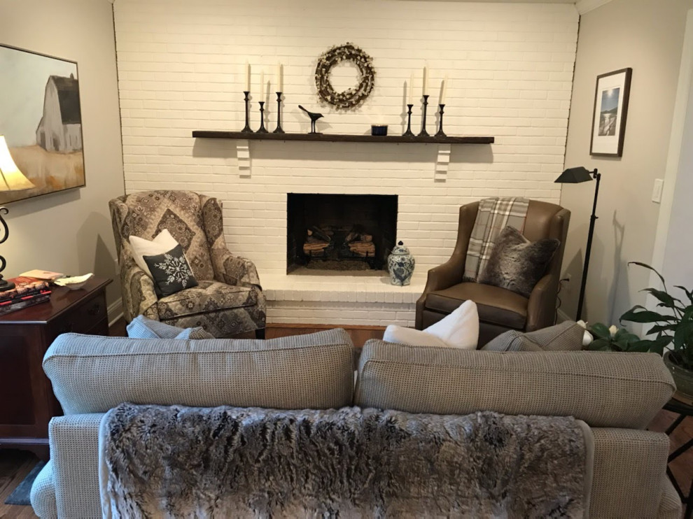 Photo of a small country open concept family room in Philadelphia with white walls, medium hardwood floors, a standard fireplace, a brick fireplace surround, a freestanding tv and brown floor.