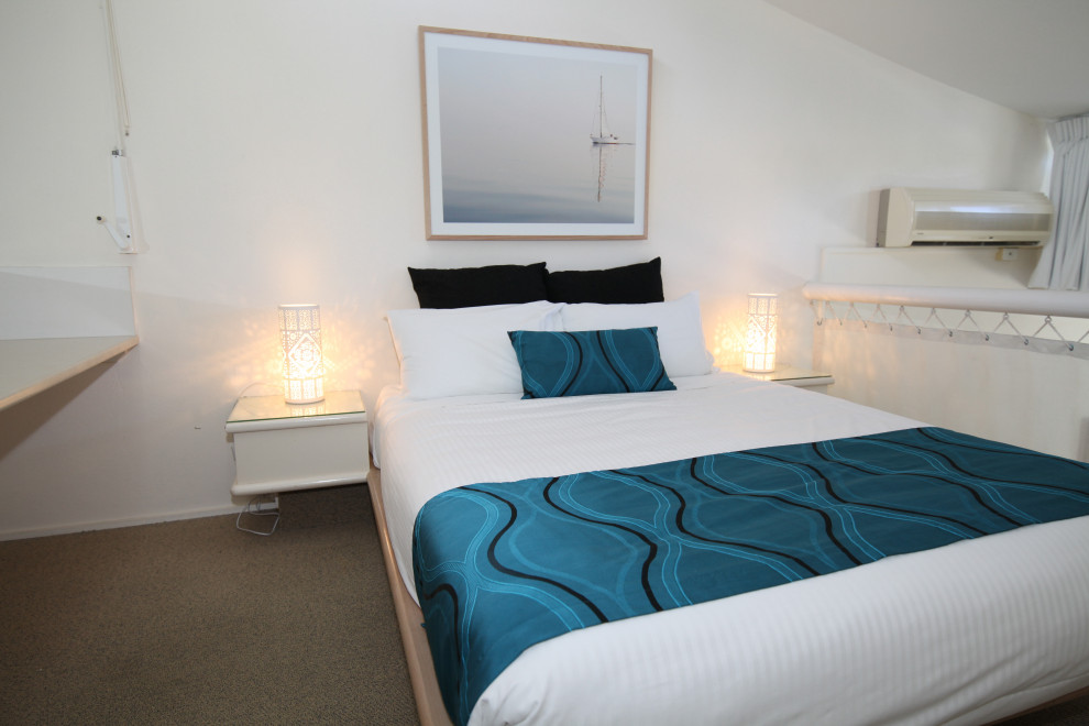 サンシャインコーストにある小さなビーチスタイルのおしゃれなロフト寝室 (白い壁、カーペット敷き、ベージュの床) のインテリア