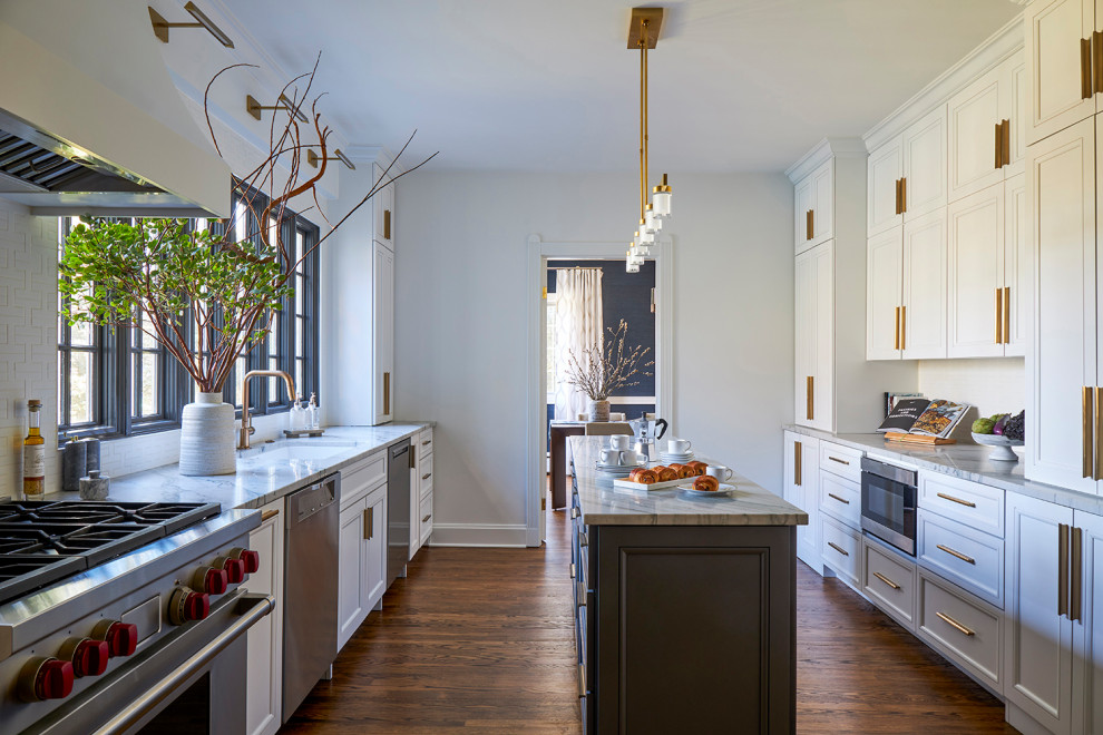 Inspiration for a mid-sized transitional galley medium tone wood floor enclosed kitchen remodel in Chicago with a single-bowl sink, recessed-panel cabinets, white cabinets, quartzite countertops, white backsplash, ceramic backsplash, stainless steel appliances, an island and white countertops