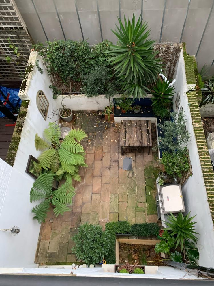 На фото: маленький летний участок и сад на внутреннем дворе в современном стиле с полуденной тенью и покрытием из каменной брусчатки для на участке и в саду