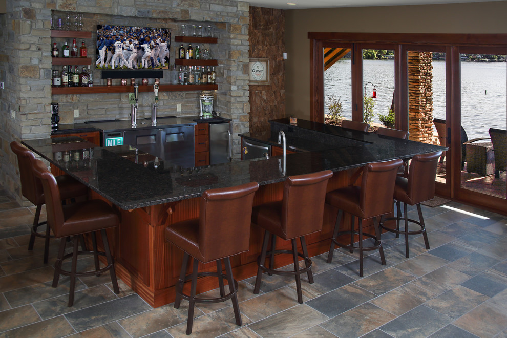 Inspiration for a mid-sized arts and crafts single-wall seated home bar in Other with flat-panel cabinets, medium wood cabinets, granite benchtops, stone tile splashback, slate floors and multi-coloured floor.