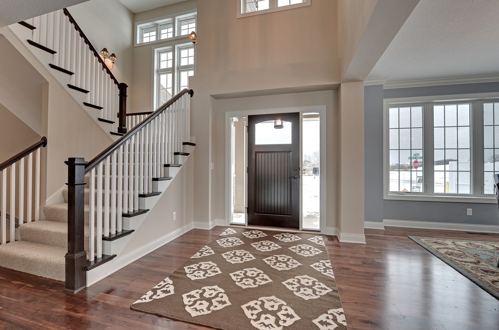 Design ideas for a large transitional foyer in Minneapolis with white walls, medium hardwood floors, a single front door and a dark wood front door.