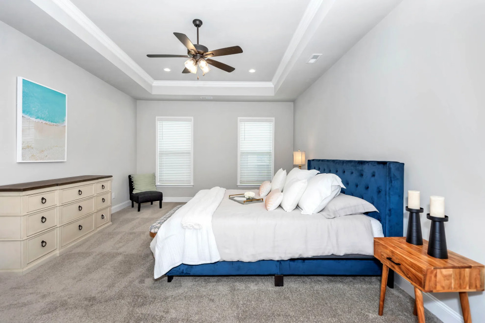 Photo of a mid-sized traditional master bedroom with grey walls, carpet and beige floor.