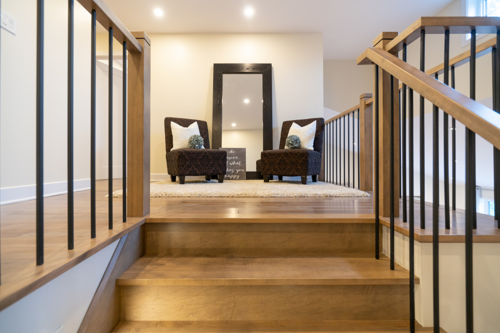This is an example of a large contemporary wood l-shaped staircase in Montreal with wood risers and wood railing.