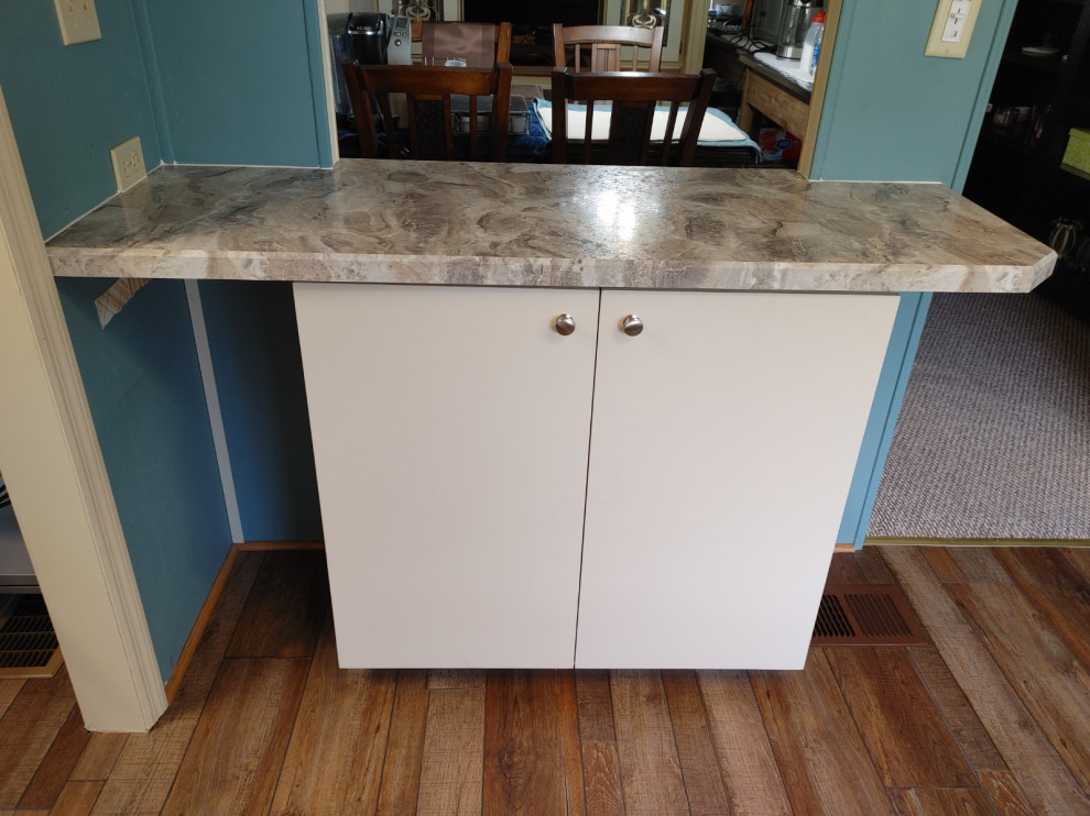 Example of a mid-sized kitchen design with white cabinets, laminate countertops, an island and beige countertops