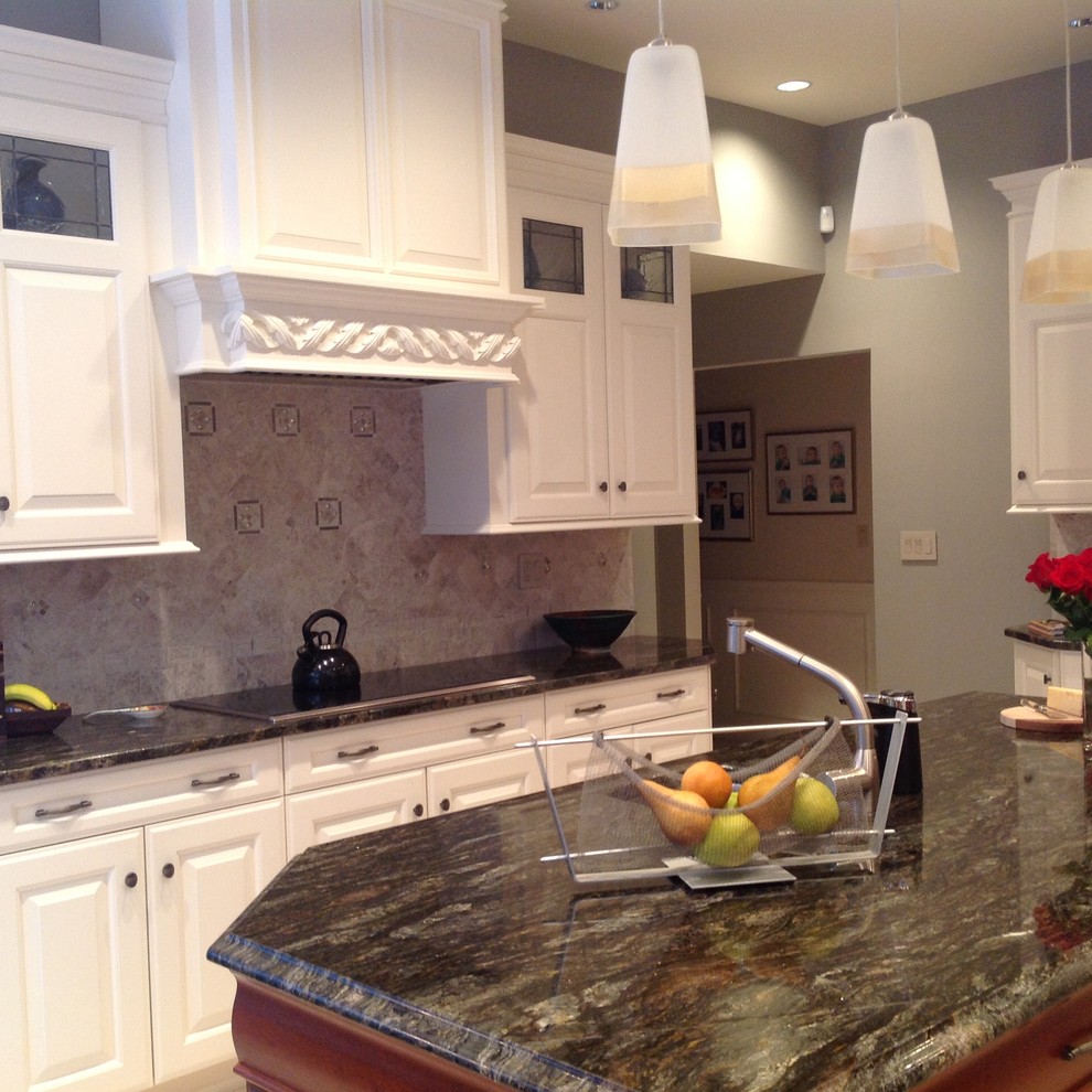 Inspiration for a mid-sized transitional u-shaped travertine floor eat-in kitchen remodel in New York with an undermount sink, raised-panel cabinets, white cabinets, granite countertops, beige backsplash, stone tile backsplash, stainless steel appliances and an island