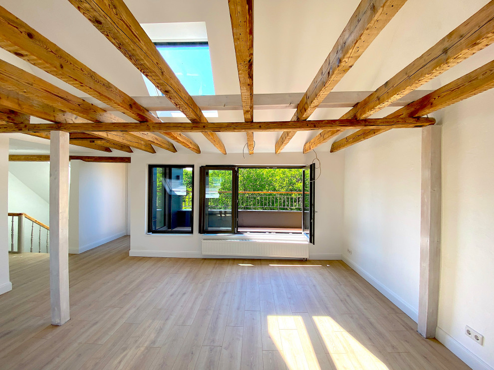 This is an example of a contemporary living room in Essen with vinyl flooring and exposed beams.