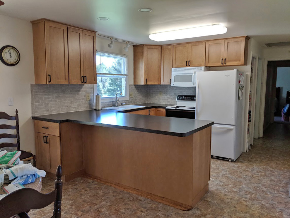 Eat-in kitchen - mid-sized transitional u-shaped linoleum floor and multicolored floor eat-in kitchen idea with a double-bowl sink, recessed-panel cabinets, light wood cabinets, laminate countertops, gray backsplash, ceramic backsplash, white appliances, a peninsula and black countertops