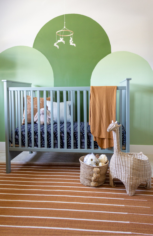 This is an example of a small contemporary gender-neutral nursery in San Diego with white walls, carpet and orange floor.