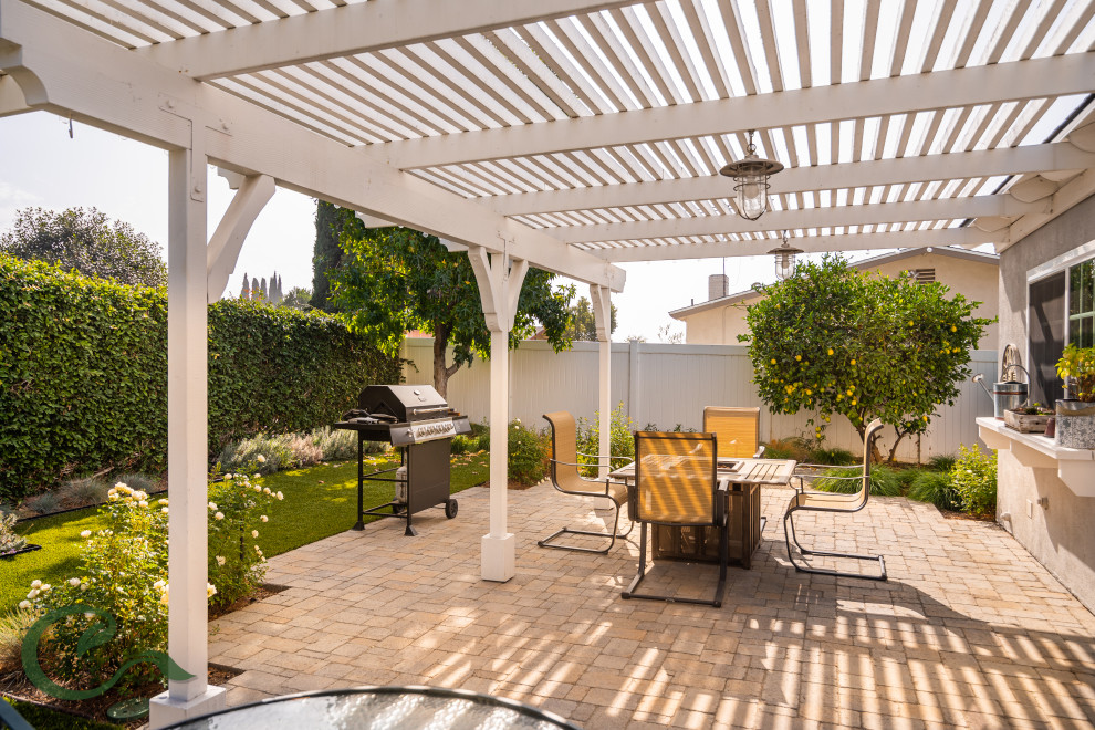 Design ideas for a mid-sized beach style backyard patio in Orange County with concrete pavers and a pergola.