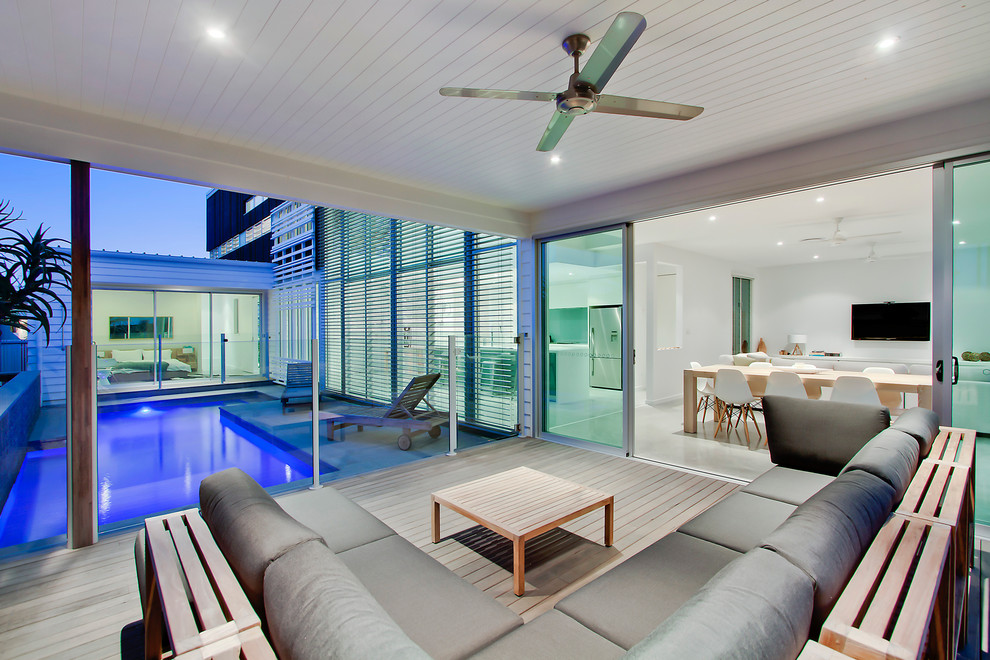 This is an example of a contemporary backyard deck in Sydney with a roof extension.