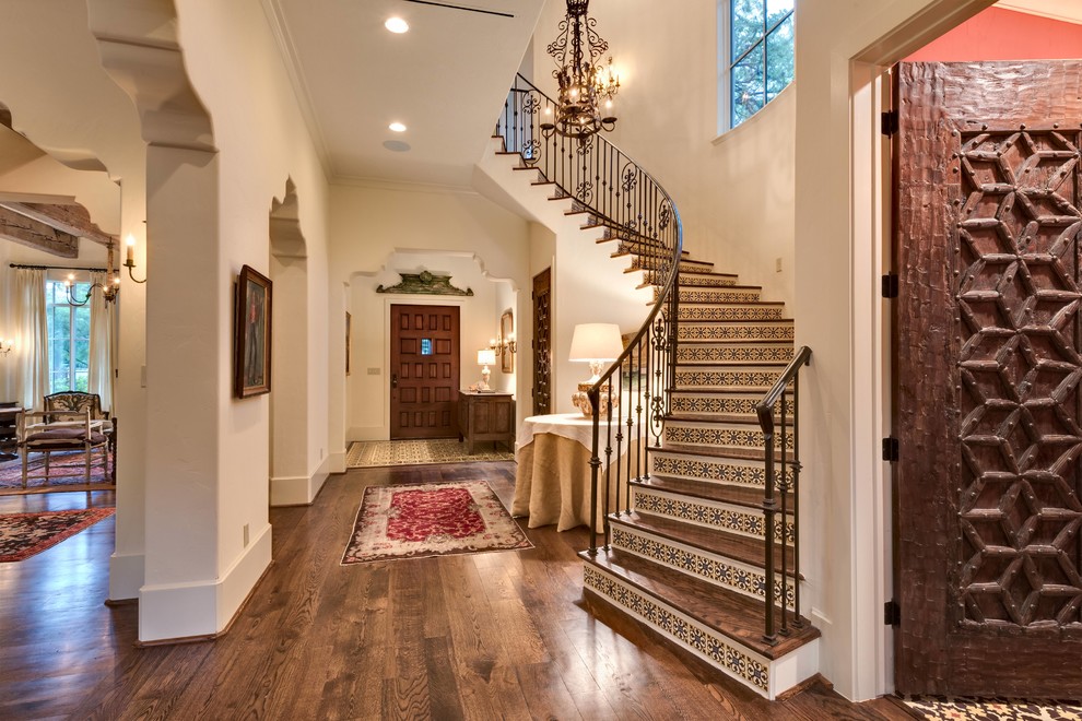 Design ideas for a large mediterranean wood curved staircase in Houston with tile risers.