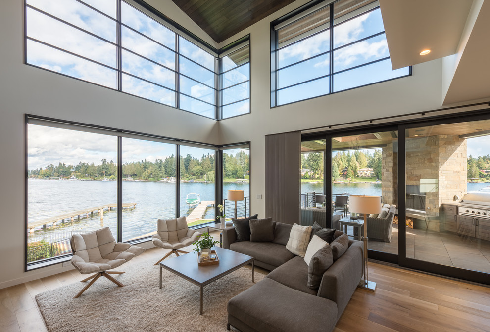 Large contemporary open concept living room in Seattle with white walls, medium hardwood floors and brown floor.