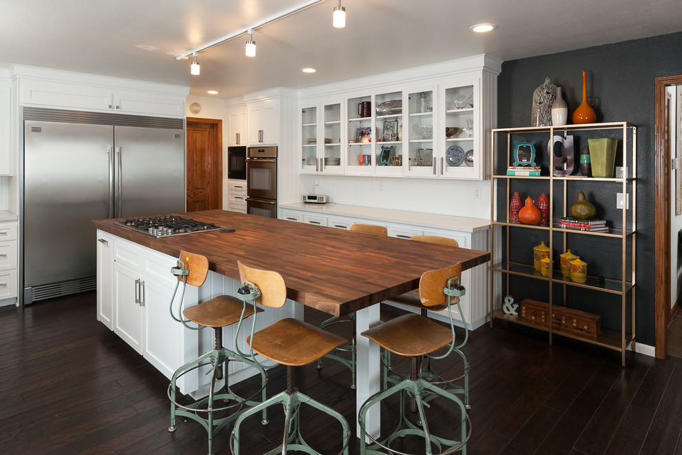 Inspiration for a large midcentury open plan kitchen in Sacramento with glass-front cabinets, white cabinets, wood benchtops, white splashback, stainless steel appliances, dark hardwood floors, with island, brown floor and brown benchtop.